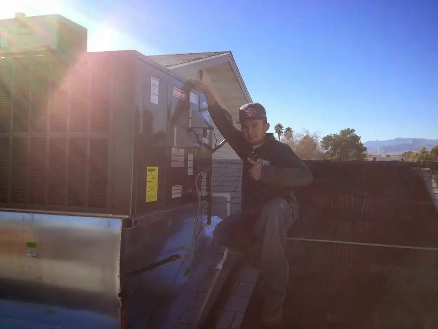 HVAC technician performing Heat Pump Repair on a rooftop unit in Murphysboro